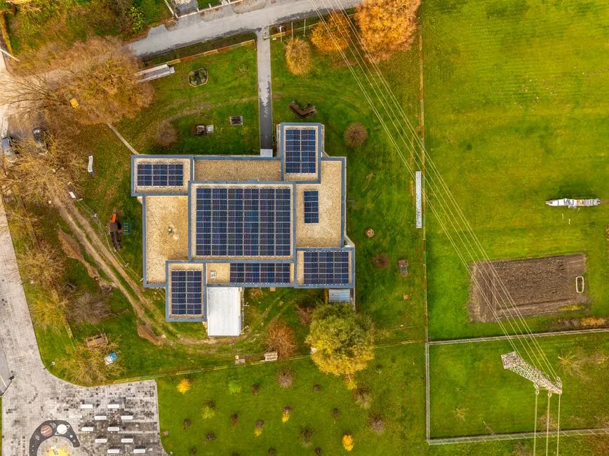 Pohľad z dronu na budovu s fotovoltickými panelmi na plochej streche