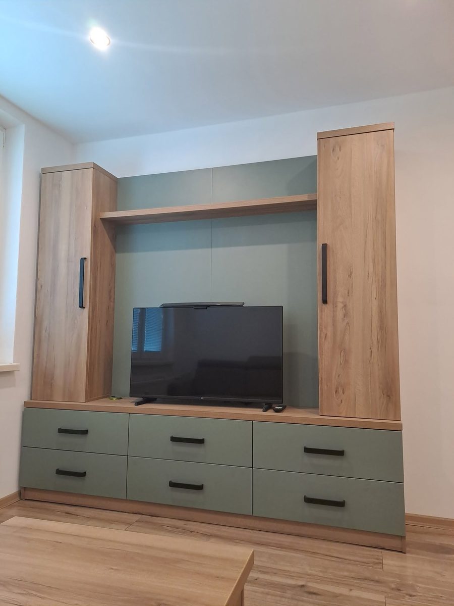 Obývacia stena v dube s miestom na televízor a šalviovo zelenými zásuvkami
